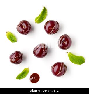 ciliegie acide ricoperte di cioccolato fuso isolate su sfondo bianco, vista dall'alto Foto Stock