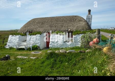 Tradizionale casa nera con paglia sull'isola di Tiree, Scozia, Regno Unito Foto Stock