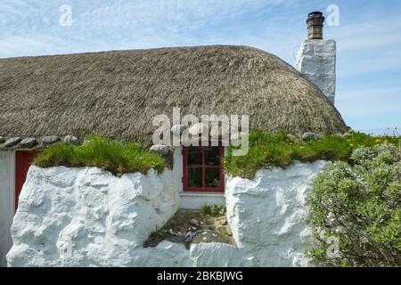 Tradizionale casa nera con paglia sull'isola di Tiree, Scozia, Regno Unito Foto Stock