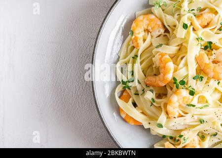 Tagliatelle di pasta italiana con salsa cremosa e gamberi. Spazio di copia. Foto Stock