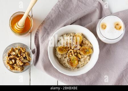 Porridge d'avena con banane al forno, caffè. Colazione sana. Foto Stock