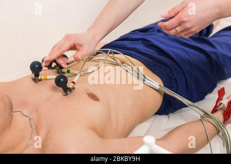 Concetto di controllo medico, sanitario e cardiaco - paziente maschile con elettrocardiogramma ECG in ospedale Foto Stock