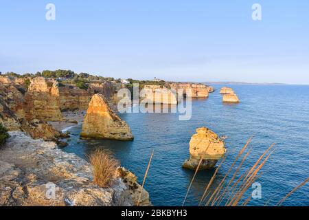 Punto di vista degli archi naturali, delle scogliere arancioni e delle acque turchesi, al tramonto. Concetto di turismo e di viaggio. Algarve, Portogallo Foto Stock