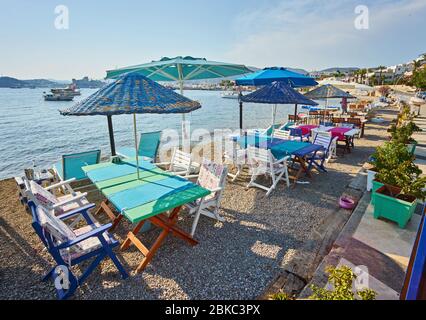 Carino tavolo e sedie e ombrellone in spiaggia al ristorante sul mare a bodrum, Turchia Foto Stock