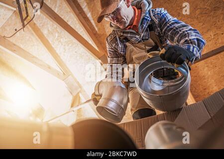 Tema industriale. Ventilazione dell'aria riscaldamento e raffreddamento operatore caucasico preparazione per il montaggio del sistema. Foto Stock