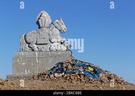 Cavallo di pietra sulla collina. Gli Ovoo sono cumuli di pietra sacra usati come altari o santuari nelle pratiche religiose popolari mongolo. Foto Stock