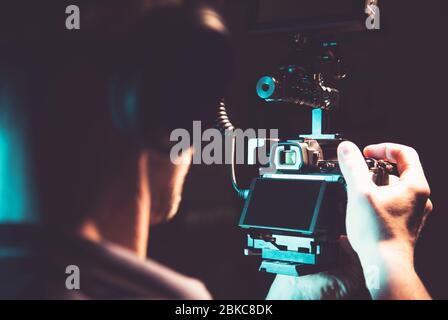 Uomini caucasici nei suoi 30 anni che prendono le riprese documentarie del palmare usando la macchina fotografica professionale DSLR. Tema videografia e Cinematografia. Foto Stock