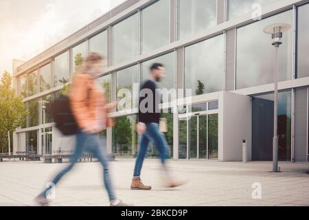 Silhouette sfocata degli studenti impegnati nel campus universitario Foto Stock