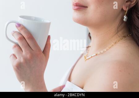 Mano della donna che tiene una tazza bianca di caffè. Con un bellissimo manicure primo piano. Drink, moda, mattina Foto Stock