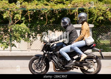 Belgrado, Serbia - 24 aprile 2020: Giovane coppia in moto a piedi su un marciapiede della città Foto Stock