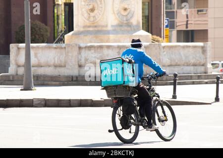 Belgrado, Serbia - 23 aprile 2020: Un corriere che lavora per il servizio di consegna di cibo Wolt a bordo di una bicicletta in città strada Foto Stock