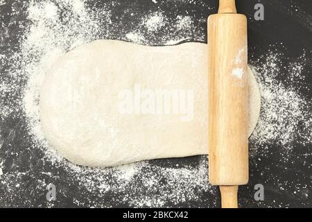 Pasta e pin di laminazione del legno su sfondo nero pulito vista dall'alto Foto Stock