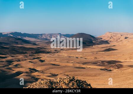 Il paesaggio del cratere ramon di Makhtesh nel deserto del Negev d'Israele. Vicino alla città di Mizpe Ramon, nel sud di Israele. Dune di sabbia in oro e nero. Bel cielo blu i Foto Stock