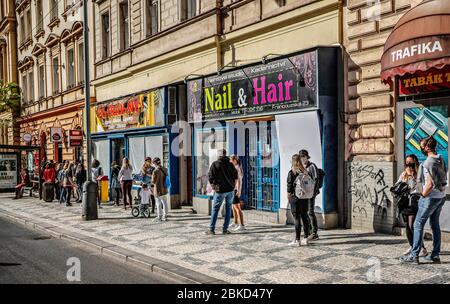 Le persone in maschere facciali stanno aspettando in un lungo spunto di fronte ad un recentemente aperto gelateria italiana Creme de la Creme nel centro di Praga, il Venerdì, M. Foto Stock