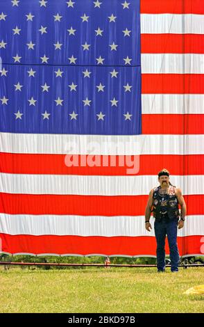 Un motociclista si trova di fronte a una gigantesca bandiera americana al Vietnam Veterans Memorial Wall dopo aver cavalcato dal Pentagono attraverso il fiume Potomac durante l'annuale Rolling Thunder rally 30 maggio 1999 a Washington, DC. Migliaia di motociclisti, molti veterani, si sono riuniti per il raduno annuale del tuono in ricordo di coloro che sono morti e scomparsi in Vietnam. Foto Stock