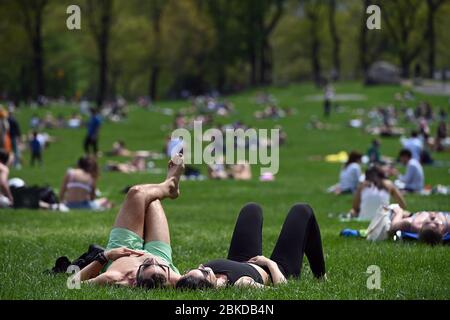 New York, Stati Uniti. 3 maggio 2020. I newyorkesi prendono al Prato delle pecore in Central Park in un caldo giorno primaverile mentre cercano di mantenere una distanza sociale adeguata di sei piedi tra (gruppi di) persone durante la pandemia COVID-19, New York, NY, 3 maggio 2020. (Anthony Behar/Sipa USA) Credit: Sipa USA/Alamy Live News Foto Stock