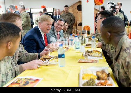 Il presidente Donald J. Trump, Unito al senatore John Barrasso, R-Wy, siede con le truppe statunitensi giovedì 28 novembre 2019 alla base aerea di Bagram, Afghanistan, durante un pasto a sorpresa del Ringraziamento. Il presidente Trump trascorre il ringraziamento con le truppe in Afghanistan Foto Stock