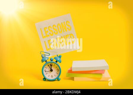 Lezioni apprese di scrittura del testo. Foto concettuale promuovere condividere e utilizzare le conoscenze derivate da esperienza Metal Alarm Clock vuoto appiccicoso nota Foto Stock