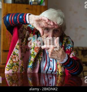 Donna anziana in abiti luminosi mostra con le mani gesto foto cornice. Foto Stock