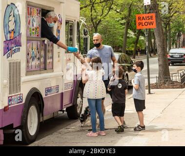 New York, Stati Uniti. 3 maggio 2020. Un padre acquista il gelato per sua figlia mentre si gode la calda giornata di primavera sul Washington Square Park in mezzo alla pandemia COVID-19 (Foto di Lev Radin/Pacific Press) Credit: Pacific Press Agency/Alamy Live News Foto Stock