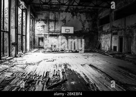 Campo da basket bianco e nero in decadenza a Pripyat, Ucraina, città abbandonata dopo il desaster nucleare di Cernobyl del 1986. Foto Stock