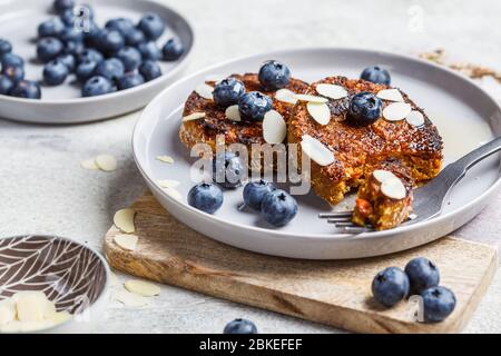 Cheesecake tofu con mirtilli su un piatto grigio. Concetto sano di cibo vegano. Foto Stock