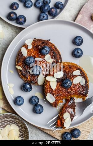 Cheesecake tofu con mirtilli su un piatto grigio. Concetto sano di cibo vegano. Foto Stock