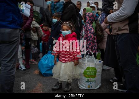 Athen, Grecia. 04 maggio 2020. Una ragazza con una guardia del boccaglio si trova nel porto del Pireo vicino ad Atene, tra gli altri migranti provenienti dal campo di Moria che sono venuti su una nave dall'isola di Lesbos. Le autorità greche hanno trasferito circa 400 migranti, per lo più famiglie, sulla terraferma per alleviare la situazione nel sovraffollato campo profughi Moria sull'isola di Lesbos. Credit: Gdban/dpa/dpa/Alamy Live News Foto Stock