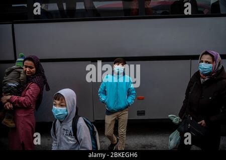 Athen, Grecia. 04 maggio 2020. I migranti con maschere facciali del campo Moria, che sono arrivati in nave dall'isola di Lesbos, si trovano nel porto del Pireo vicino ad Atene dopo il loro arrivo. Le autorità greche hanno trasferito circa 400 migranti, per lo più famiglie, sulla terraferma per alleviare la situazione nel sovraffollato campo profughi di Moria sull'isola di Lesbos. Credit: Gdban/dpa/dpa/Alamy Live News Foto Stock