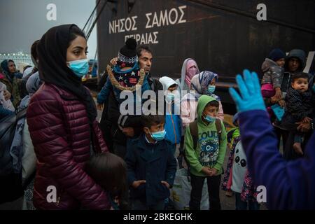 Athen, Grecia. 04 maggio 2020. I migranti con maschere facciali del campo Moria, che sono arrivati in nave dall'isola di Lesbos, si trovano nel porto del Pireo vicino ad Atene dopo il loro arrivo. Le autorità greche hanno trasferito circa 400 migranti, per lo più famiglie, sulla terraferma per alleviare la situazione nel sovraffollato campo profughi di Moria sull'isola di Lesbos. Credit: Gdban/dpa/dpa/Alamy Live News Foto Stock