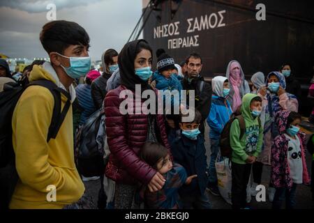 Athen, Grecia. 04 maggio 2020. I migranti con maschere facciali del campo Moria, che sono arrivati in nave dall'isola di Lesbos, si trovano nel porto del Pireo vicino ad Atene dopo il loro arrivo. Le autorità greche hanno trasferito circa 400 migranti, per lo più famiglie, sulla terraferma per alleviare la situazione nel sovraffollato campo profughi di Moria sull'isola di Lesbos. Credit: Gdban/dpa/dpa/Alamy Live News Foto Stock