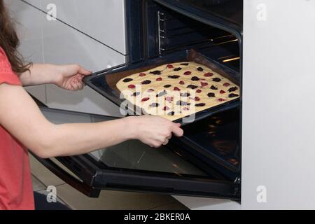 Donne mani che impacca torta in forno. Dessert al forno. Cucina in casa cucina. Cottura fatta in casa Foto Stock