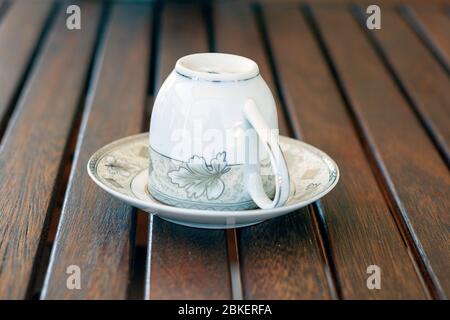 Capovolta tazza di caffè turca sopra il piattino tradizionalmente usando per la fortuna che racconta sulla tavola di legno, la fortuna di caffè che racconta Foto Stock