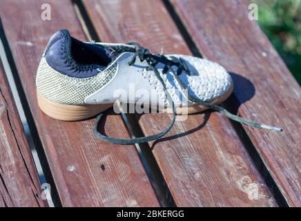 scarpa da bambino indossata lasciata sul banco Foto Stock