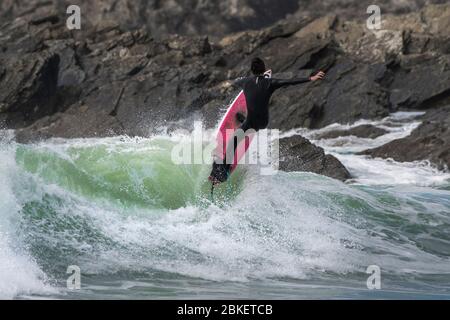 Azione spettacolare come un surfista prende in aria da un'onda a Fistral a Newquay in Cornovaglia. Foto Stock