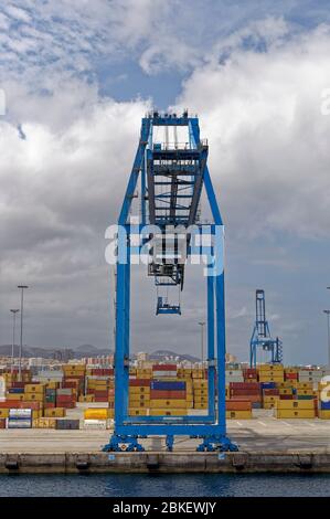 Una grande gru per container si trova sul molo del porto container di Las Palmas di fronte ai container Stacked Shipping Containers. Foto Stock