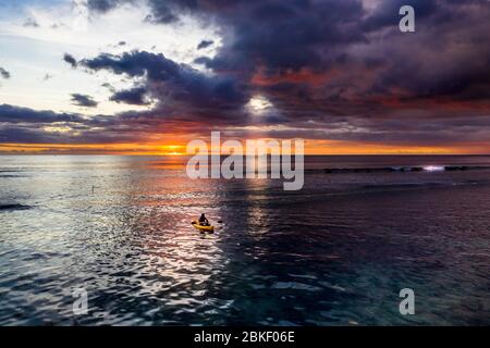 Vista aerea, canoa in mare al tramonto drammatico con tuubi di tuoni, costa di Flic en Flac, Mauritius Foto Stock