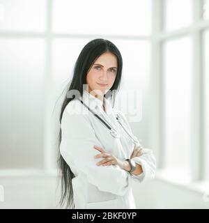 Terapista del sesso femminile in piedi dalla finestra dell'ospedale Foto Stock