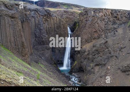 Lunga esposizione della splendida cascata di Littanesfoss, dove l'acqua cade tra le massicce geologie delle colonne basaltiche, l'Islanda. Foto Stock