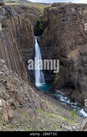 Lunga esposizione della splendida cascata di Littanesfoss, dove l'acqua cade tra le massicce geologie delle colonne basaltiche, l'Islanda. Foto Stock