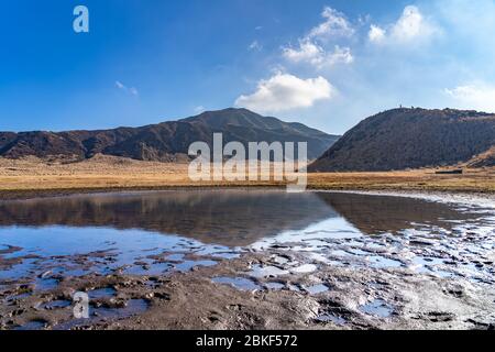 Kusasenri (kusasenri-ga-hama) prateria nel mese di gennaio, Mt. Eboshi riflette attraverso lo stagno. Parco Nazionale di ASO Kuju, Prefettura di Kumamoto, Giappone Foto Stock