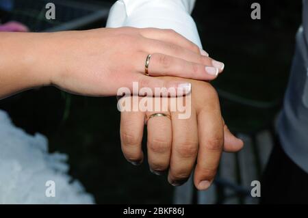 Anelli d'oro nelle mani dello sposo e della sposa nel giorno del loro matrimonio. Foto Stock