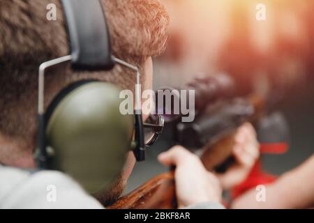 L'uomo dirige la pistola da arma da fuoco a portata di tiro o a portata di tiro. Foto Stock