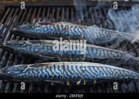 Pesce crudo alla griglia, cucina o in preparazione durante il festival alimentare di strada o mercato del pesce. Ricetta semplice alla trota, cucinata senza erbe e spezie. Fresco F Foto Stock