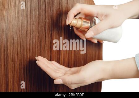 Mani parrucchieri primo piano rende l'applicazione di olio per la separazione di estremità di potere proteggere, riparare la struttura danneggiata. Concetto di salute e crescita dei capelli Foto Stock