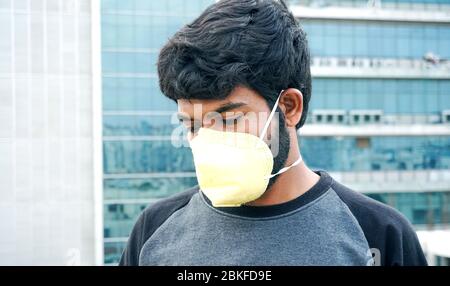 Uomo indiano in maschera protettiva gialla Foto Stock