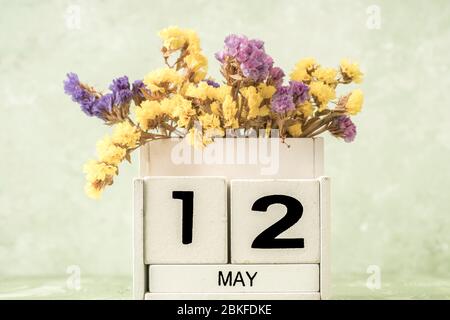 Calendario cubo bianco per maggio decorato con fiori su sfondo verde con spazio copia Foto Stock