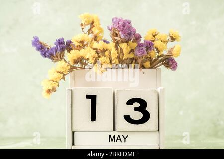 Calendario cubo bianco per maggio decorato con fiori su sfondo verde con spazio copia Foto Stock