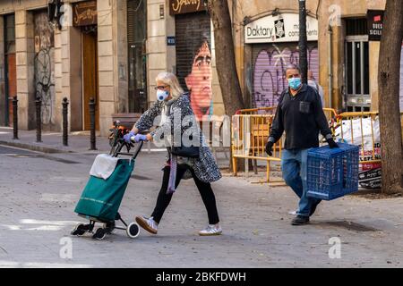 Barcellona, Spagna. 4rd Maggio, 2020. Coppia di trasporto di oggetti attraverso le strade del centro di Barcellona ai tempi di un'accovida chiusura a chiave Foto Stock