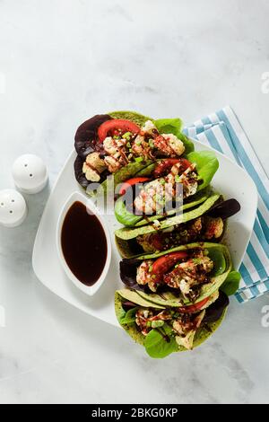 tachicchi verdi di vegano senza glutine a base di farina di ceci con spinaci e condimenti a base di cavolfiore al forno e lattuga con salsa dolce e acide a base di o Foto Stock